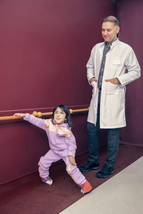 Specialist supporting a child at the therapy barre