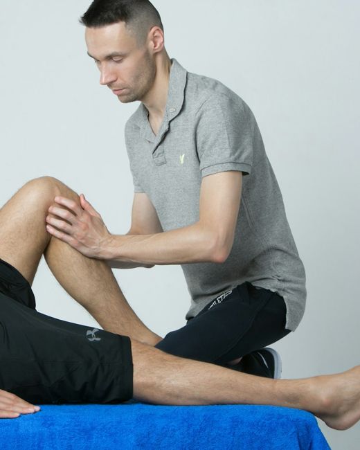 Physiotherapist assessing a patient's knee mobility at Trivas Neuron